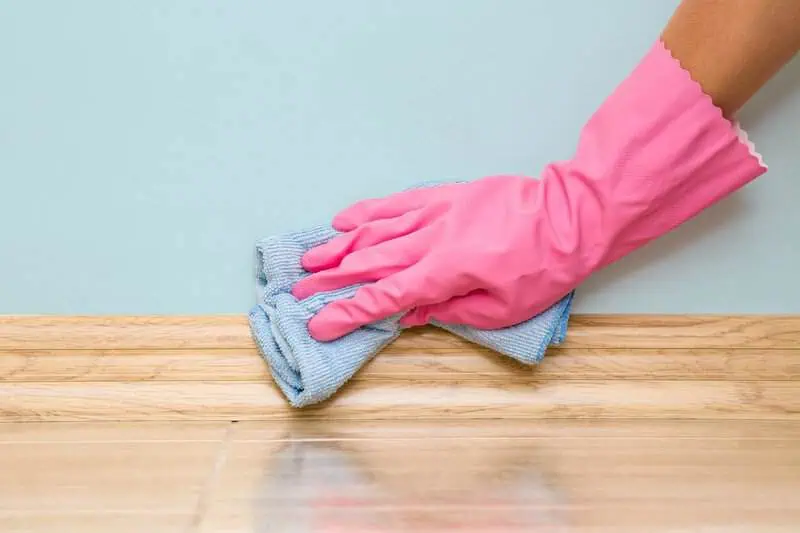 cleaning baseboards and corners to remove dust buildup